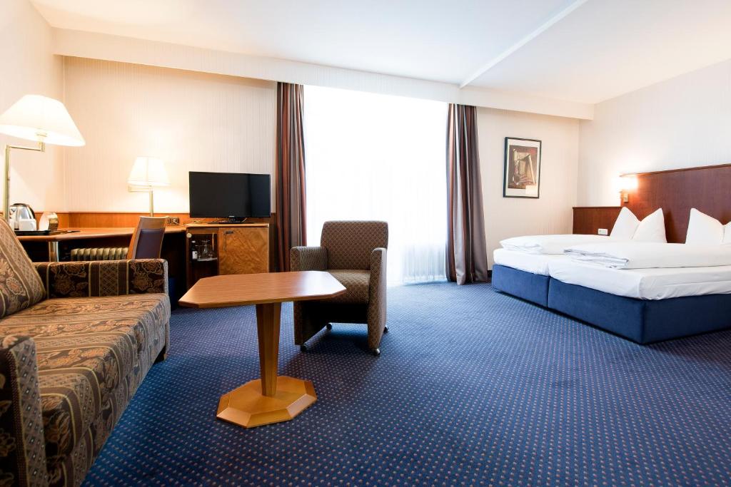 pokój hotelowy z łóżkiem i kanapą w obiekcie domus Hotel w Monachium