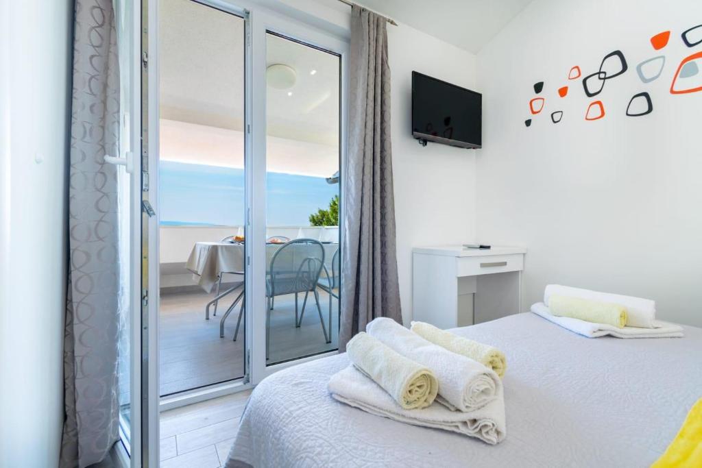 een slaapkamer met een bed en uitzicht op de oceaan bij Apartman Mimi in Baška Voda
