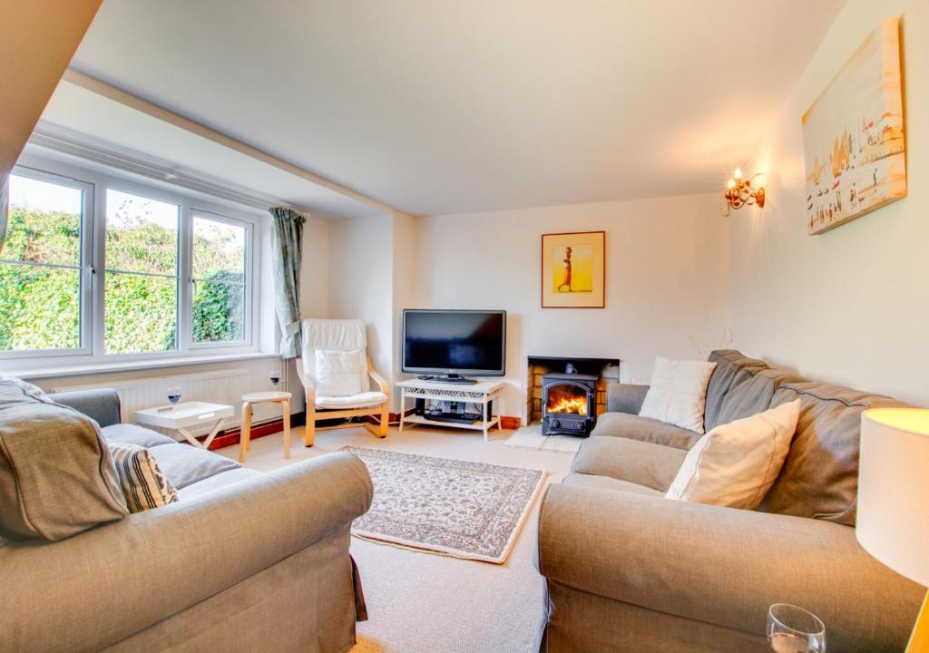 a living room with two couches and a tv at Haven Cottage in South Walsham