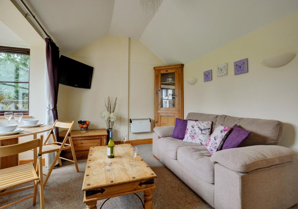 un salon avec un canapé et une table dans l'établissement Holly Cottage, à Banningham