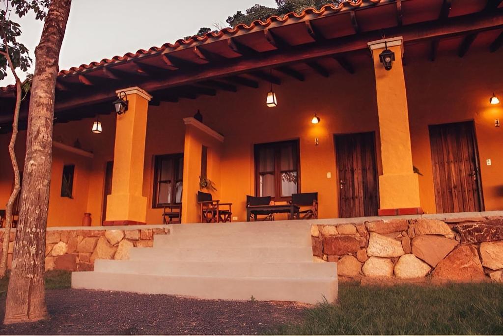 a house with a stone wall and stairs in front at KAROBÉ Posada Boutique in San Bernardino