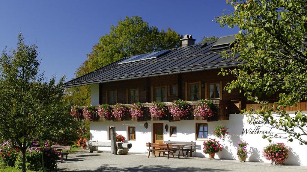 ein großes weißes Gebäude mit Blumenkästen drauf in der Unterkunft Haus Widlbrandlehen in Schönau am Königssee