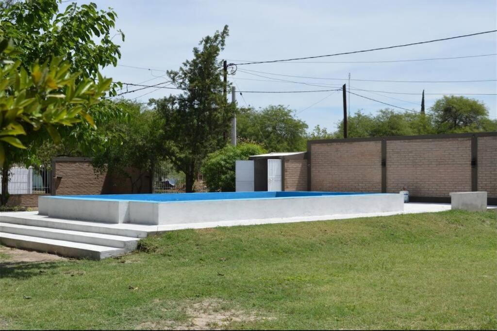 een zwembad in een tuin met gras bij Casa con pileta in Santiago del Estero