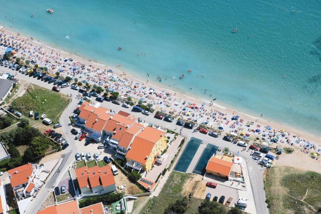 an aerial view of a beach with a crowd of people at Apartments Capic in Baška