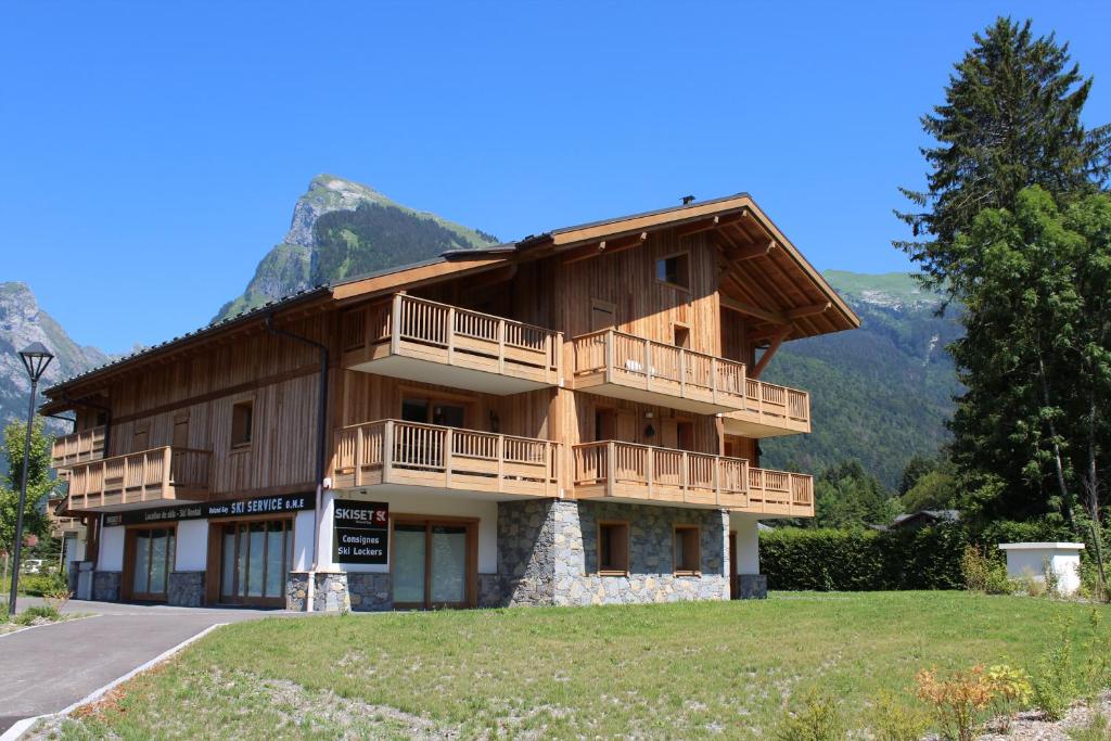 a large wooden building with a mountain in the background at RESIDENCE SASKYA in Samoëns
