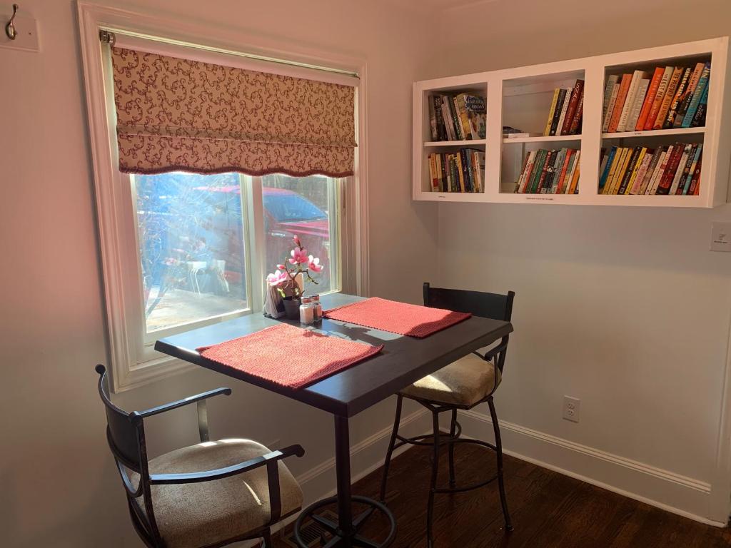 mesa de comedor con 2 sillas y ventana en Briar Creek Rd bnb en Charlotte