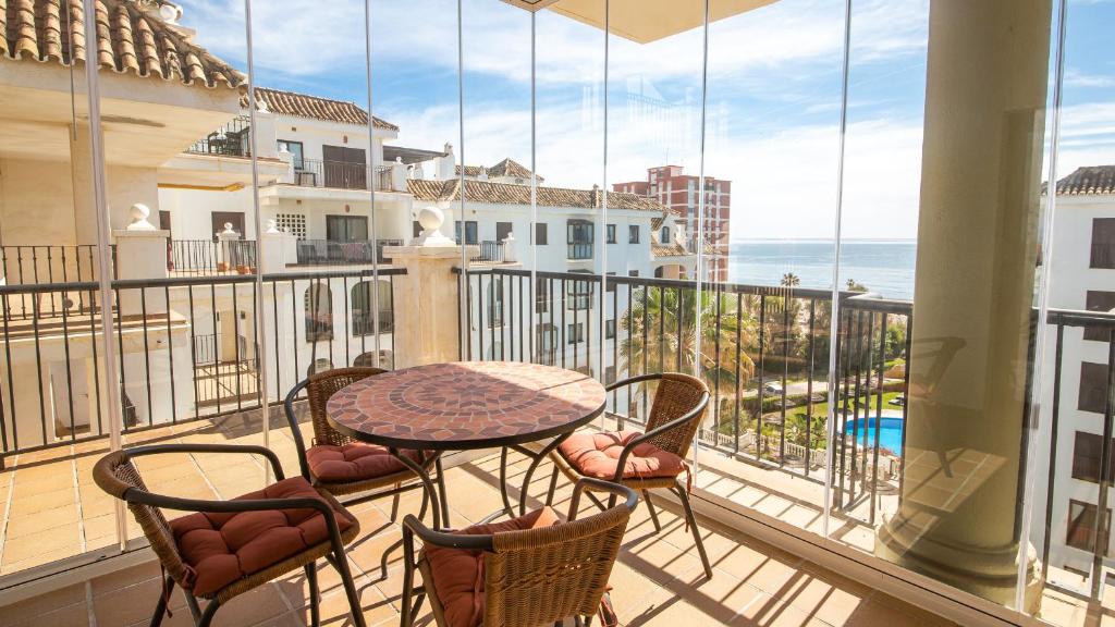 een balkon met een tafel en stoelen en de oceaan bij Marina Duquesa 544 in Manilva