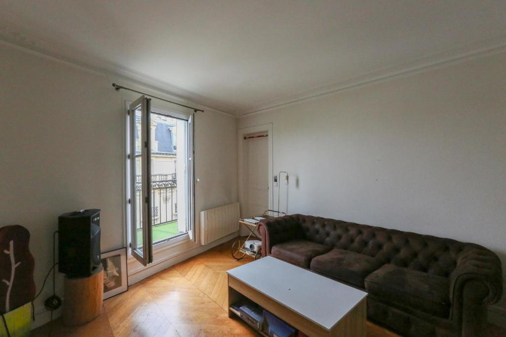 ein Wohnzimmer mit einem Sofa und einem Fenster in der Unterkunft Comfortable and spacious apartment in Paris 3rd in Paris