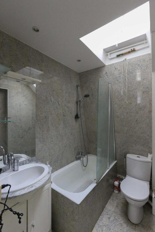 ein Badezimmer mit einer Badewanne, einem WC und einem Waschbecken in der Unterkunft Comfortable and spacious apartment in Paris 3rd in Paris