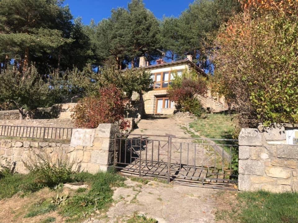 ein Haus mit einem Zaun davor in der Unterkunft Los Rosales de Gredos in Hoyos del Espino