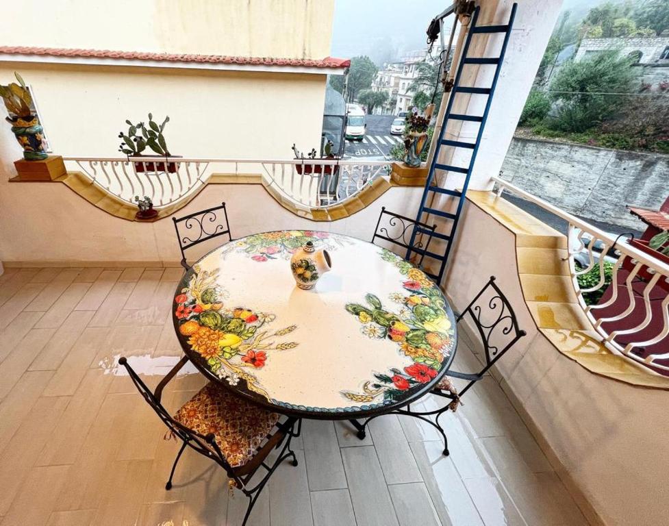 a table and chairs on a balcony with a view at Apartment TAORMINA center with TERRACE, via Celestino Penna 6 in Taormina