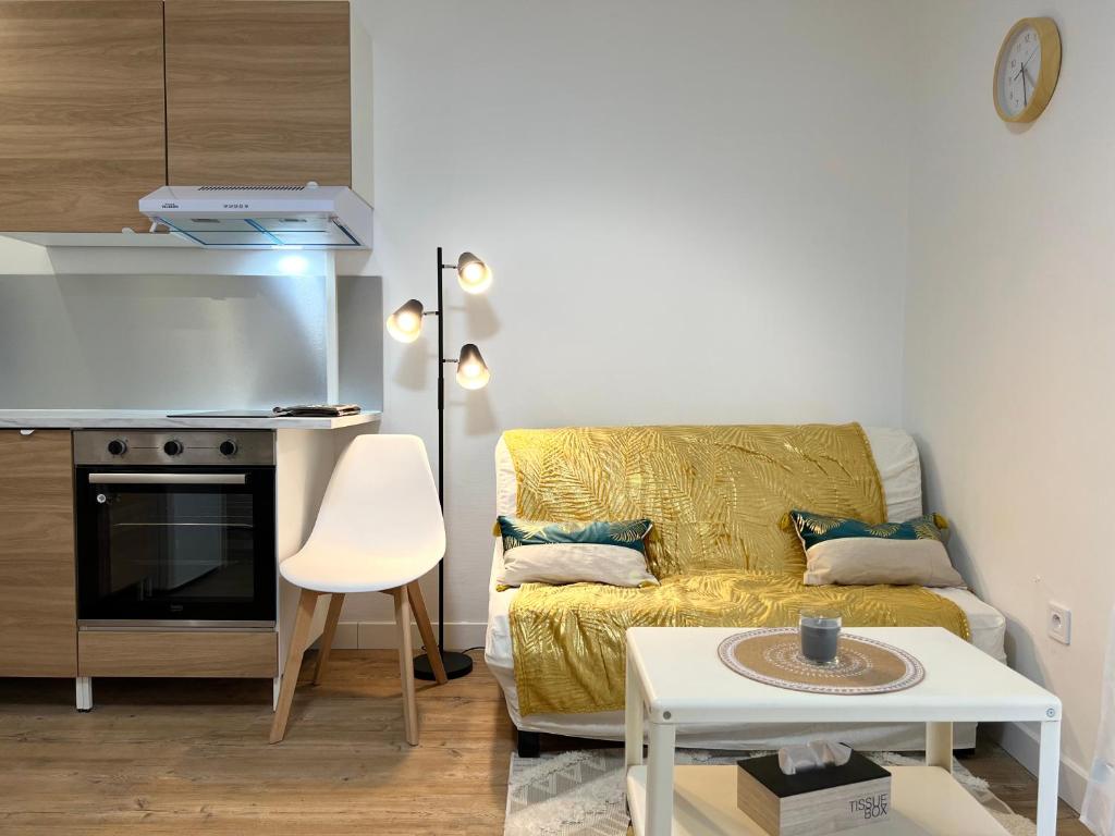 un salon avec un canapé jaune et une table dans l'établissement Appartement cosy à Toulouse, à Toulouse