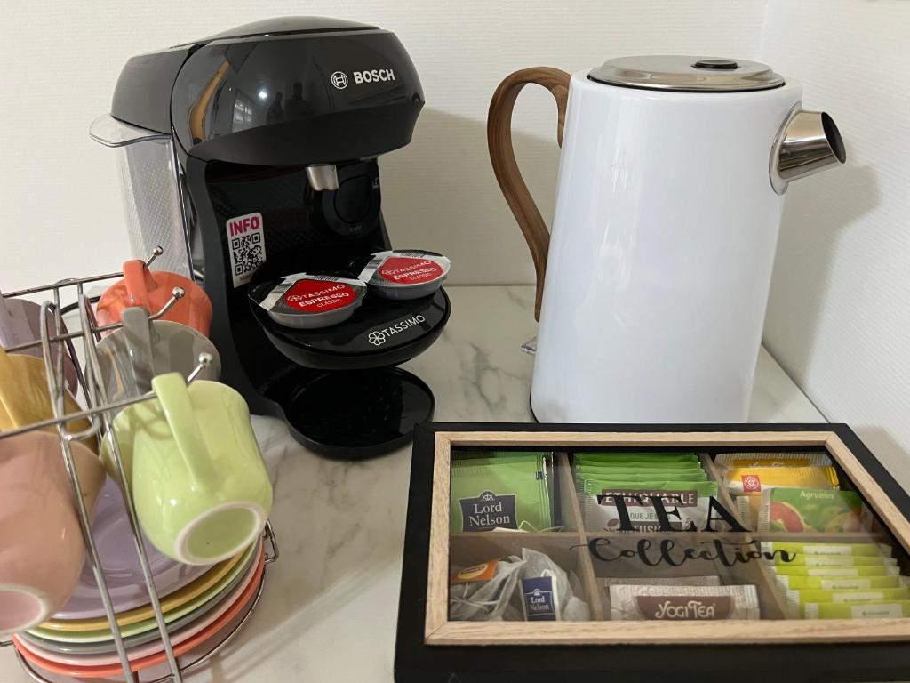 a counter with a coffee maker and a box of food at Appartement cosy à Toulouse in Toulouse