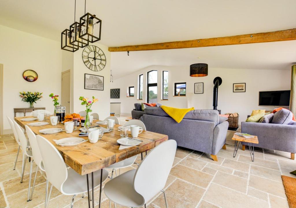 a living room with a large wooden table and chairs at Muntjac Barn in Briston