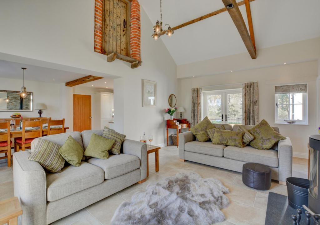 a living room with two couches and a dining room at Mill Cottage in Elsing