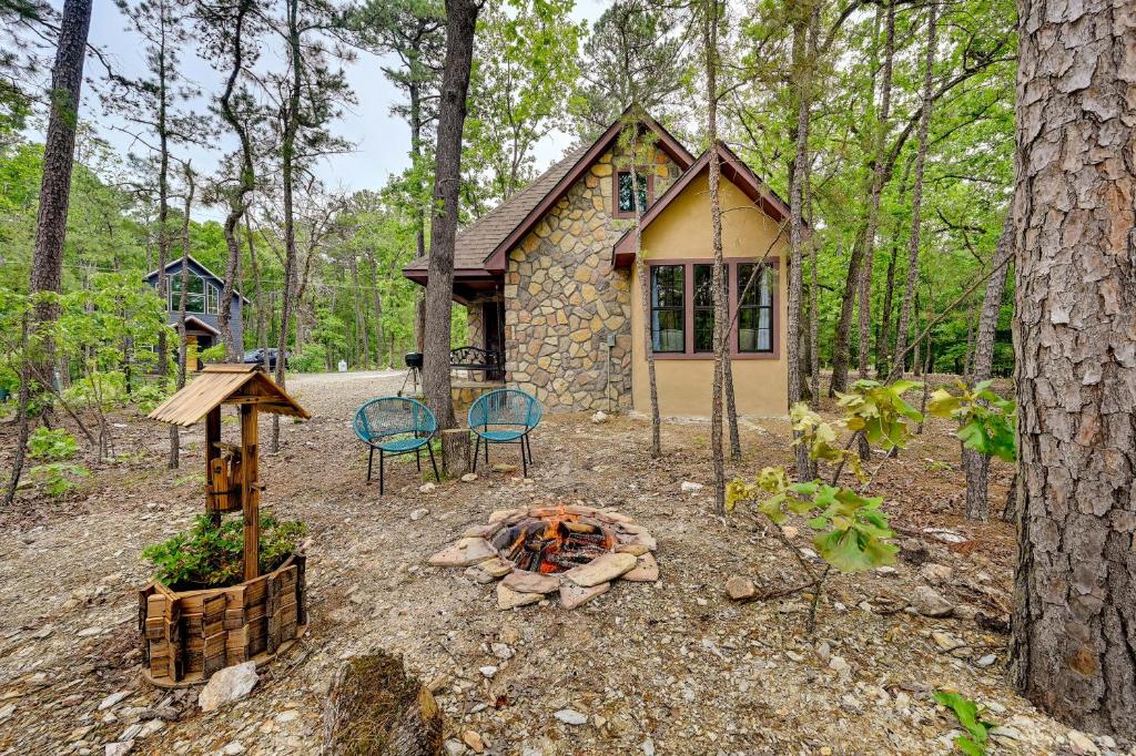 a cabin in the woods with a fire in front of it at Blissful Broken Bow Vacation Rental with Fire Pit! in Broken Bow