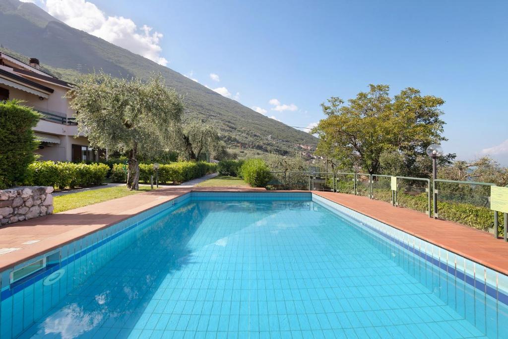 a swimming pool with a mountain in the background at Appartamento Assenza 9 in Brenzone sul Garda