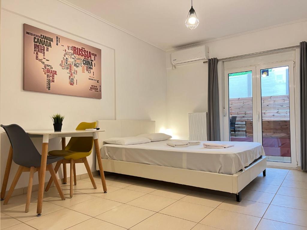 a bedroom with a bed and a desk and a table at Jacuzzi studio close to athens airport!! in Pallíni