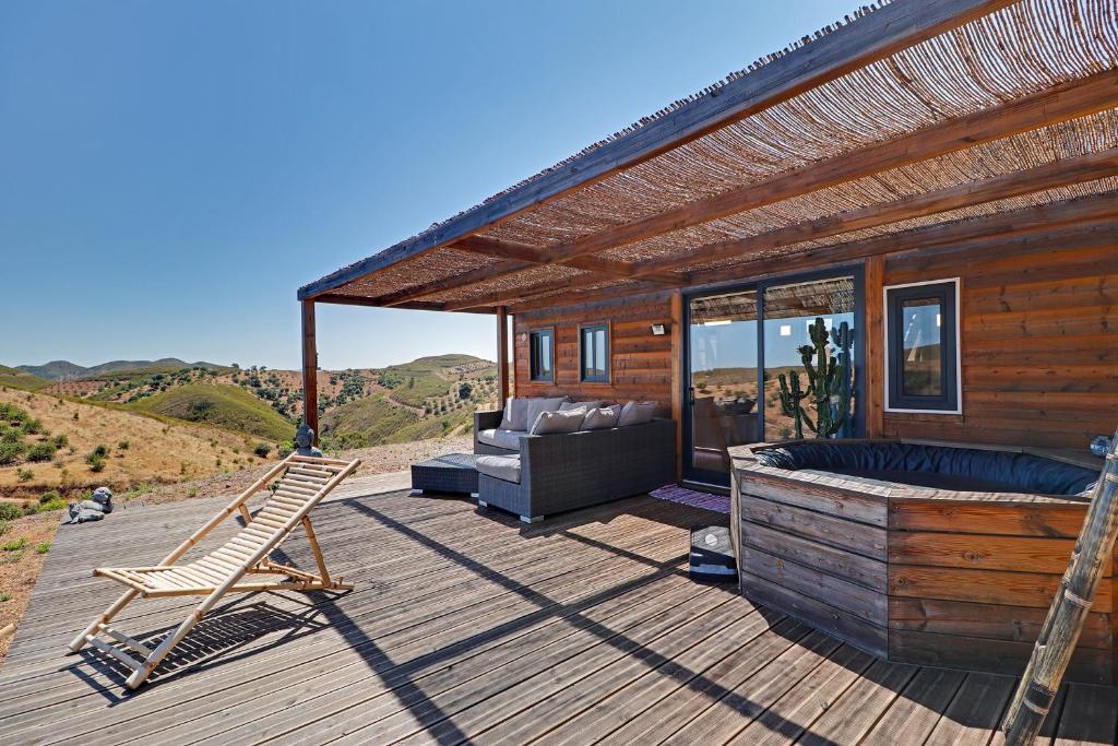 una terrazza con divano e sedia su una casa di Portugals Infinity - Fantástica casa de campo com vista de mar a Tavira