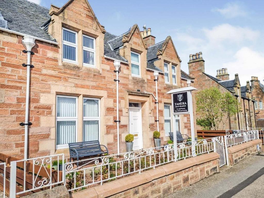 a row of brick houses with a bench on a street at Tanera in Inverness