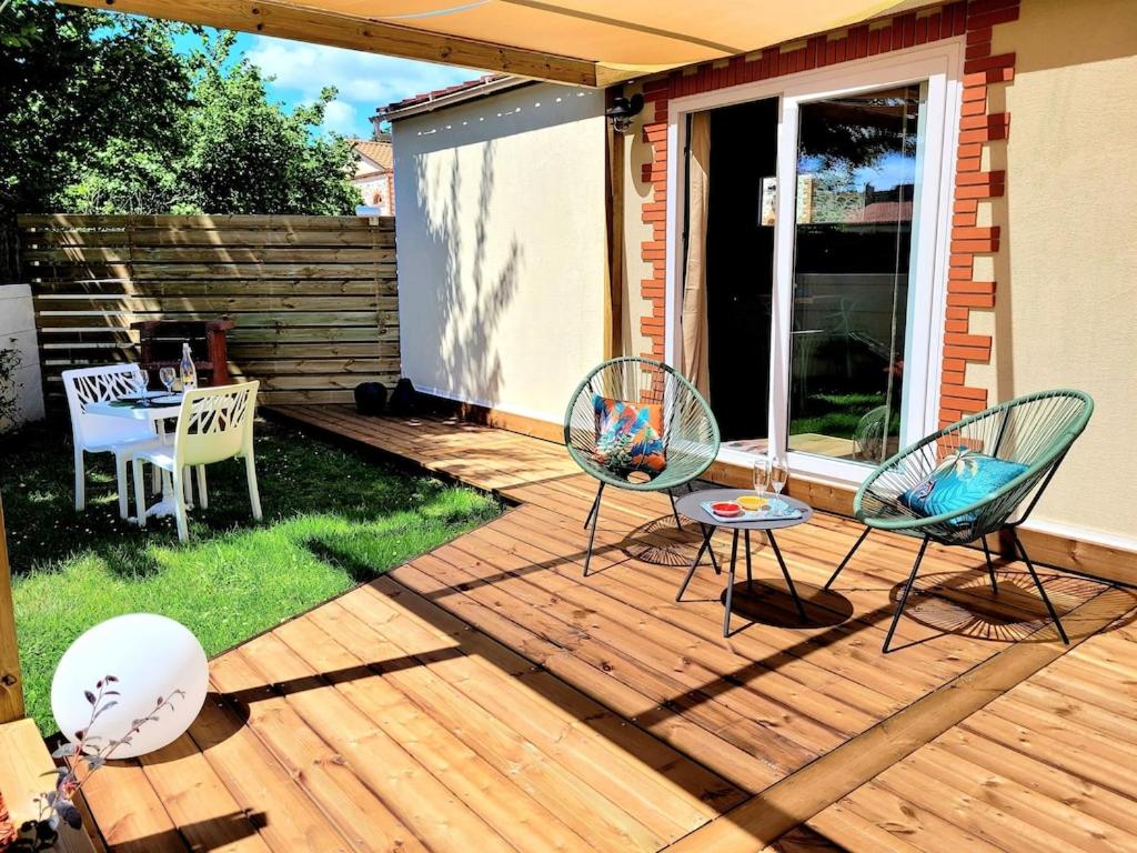Saint-Aignan-Grand-LieuにあるCopacabana TINY HOUSE studio terrasse jardinの木製デッキ(椅子2脚、テーブル1台付)