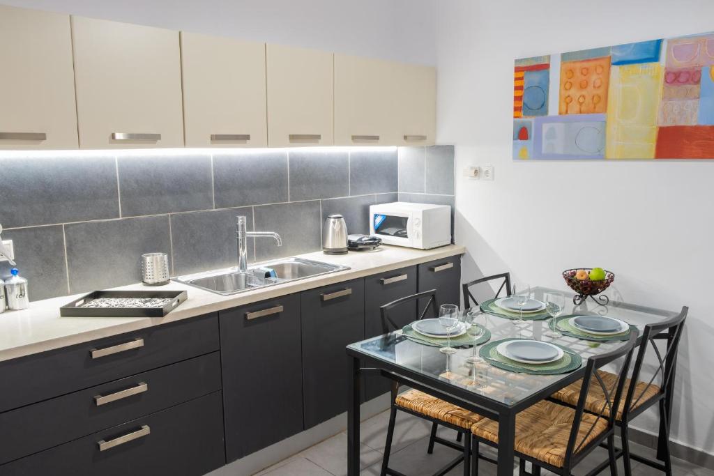 uma cozinha com uma mesa com pratos em Aneseas Syros em Hermópolis