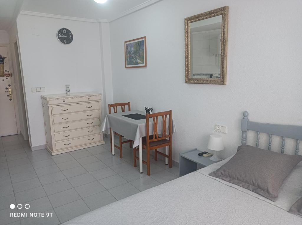 1 dormitorio con 1 cama, mesa y sillas en Studio Almudena, en Torrevieja