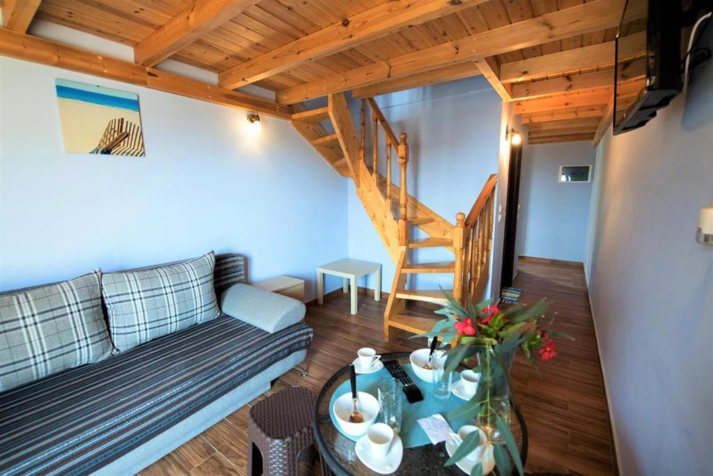 a living room with a couch and a staircase at Argo Apartments in Vasiliki