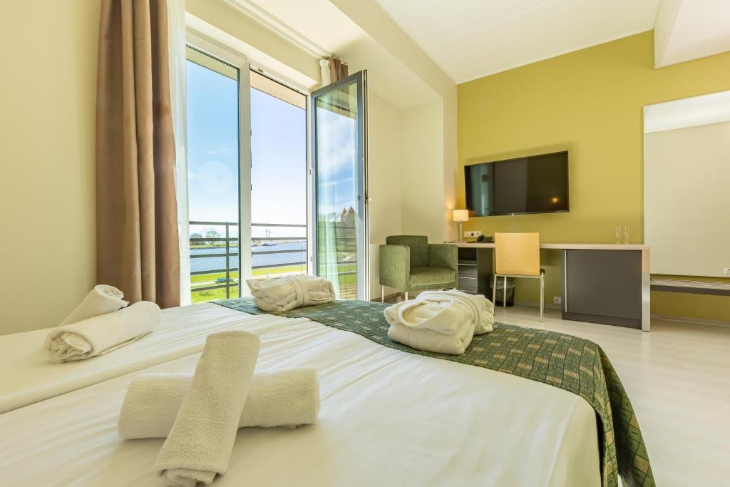 a bedroom with a large bed with a large window at Meri Seaside Hotel & SPA in Kuressaare