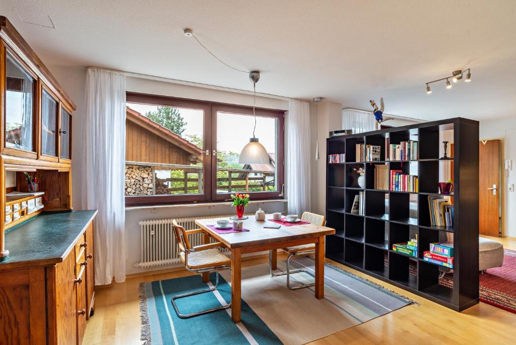 a dining room with a table and a book shelf at Ferienwohnung Fasse in Bühlertal