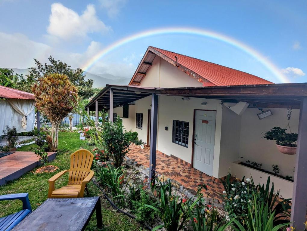 un arcobaleno sopra una casa con due sedie di Jardín del Edén a Bajo Boquete