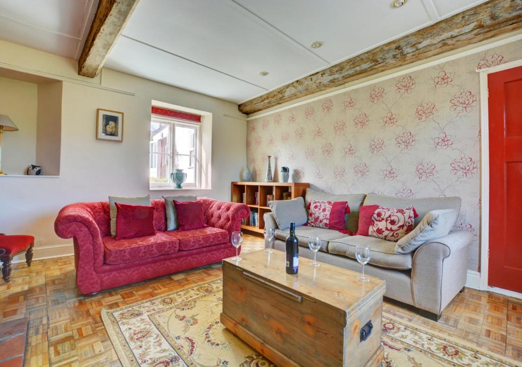 - un salon avec un canapé et une table dans l'établissement Owl Cottage, à Little Walsingham