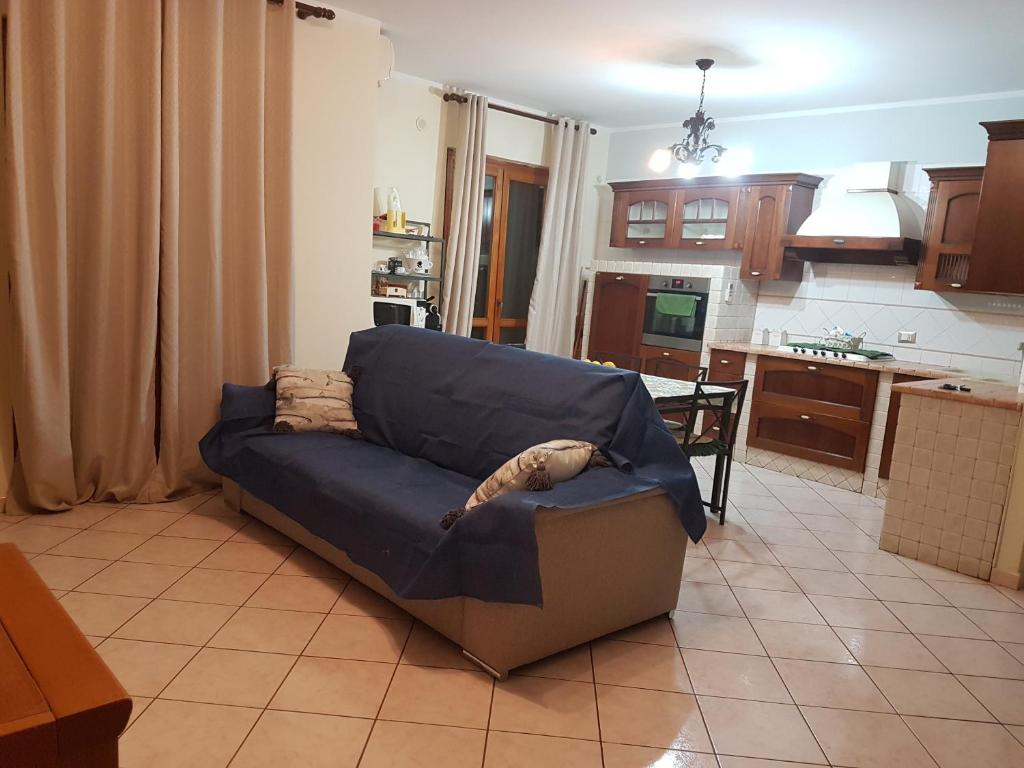 een woonkamer met een blauwe bank in een keuken bij Just Pompei Holiday House in Scafati
