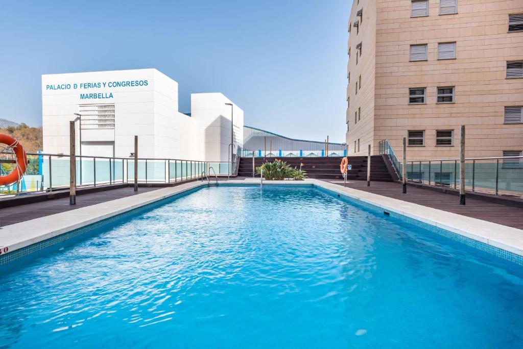 a swimming pool in front of a building at Apartamento Marbella Center III in Marbella