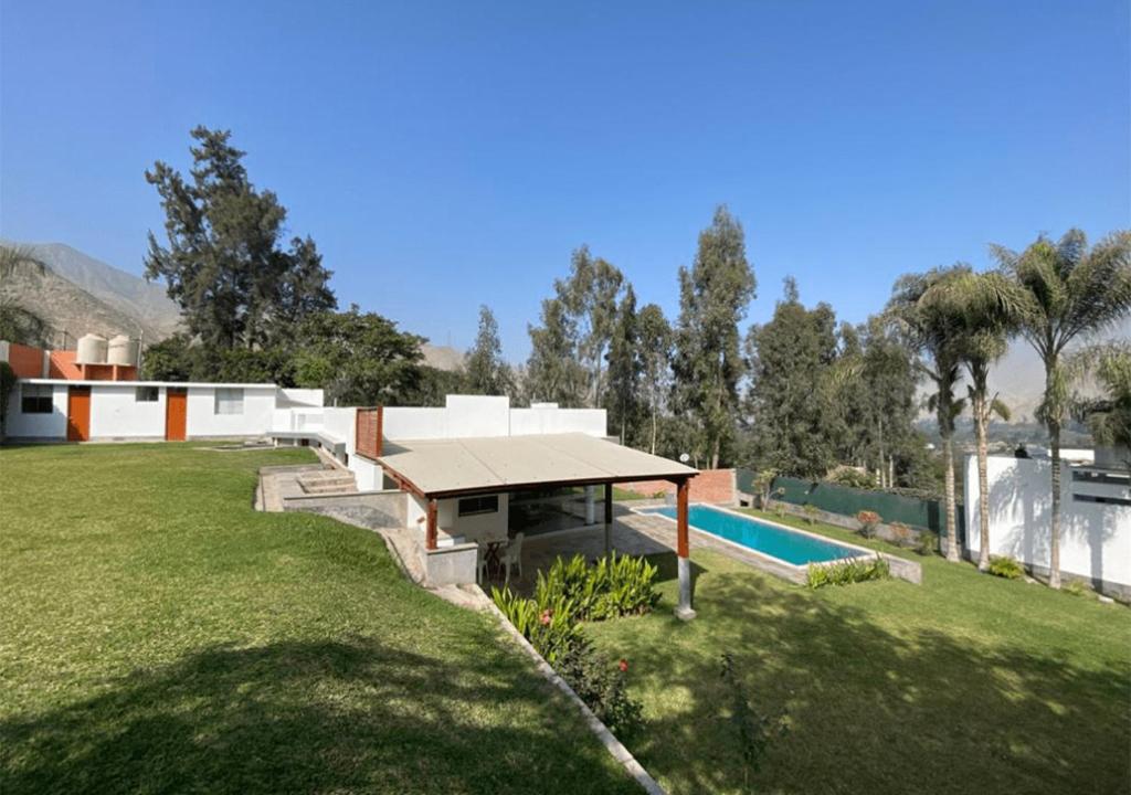 a backyard with a swimming pool and a house at KUSI WASI CIENEGUILLA in Cieneguilla