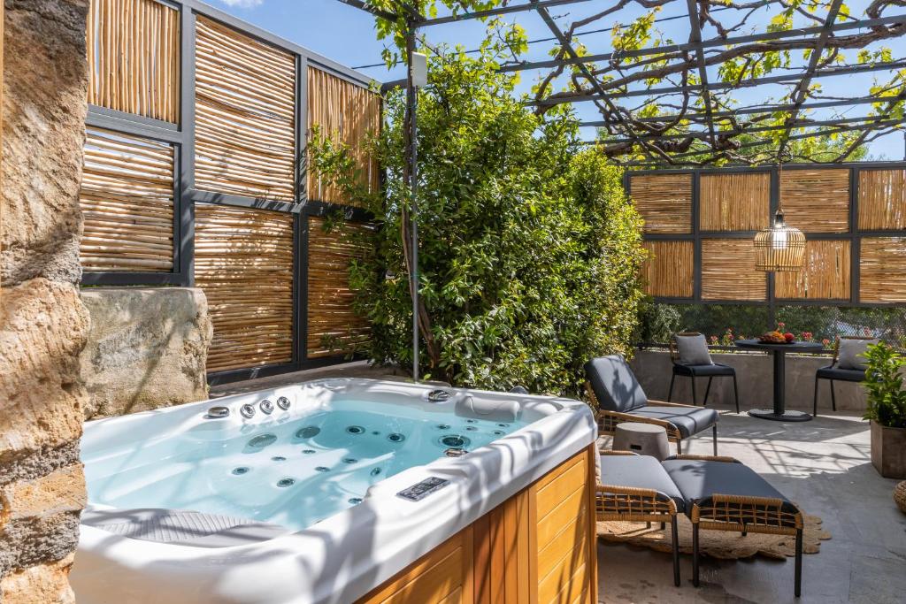 an outdoor jacuzzi tub in a backyard with a patio at Villa Dimitra - Saint Nikolas Retreat in Faraklata