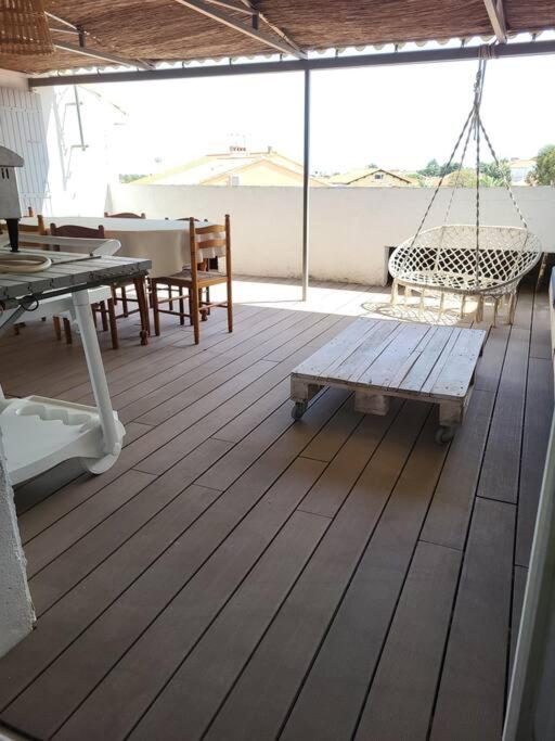 - une terrasse couverte avec un hamac, une table et des chaises dans l'établissement Appartement au 2éme étage terrasse 30m2, à Saint-Cyprien