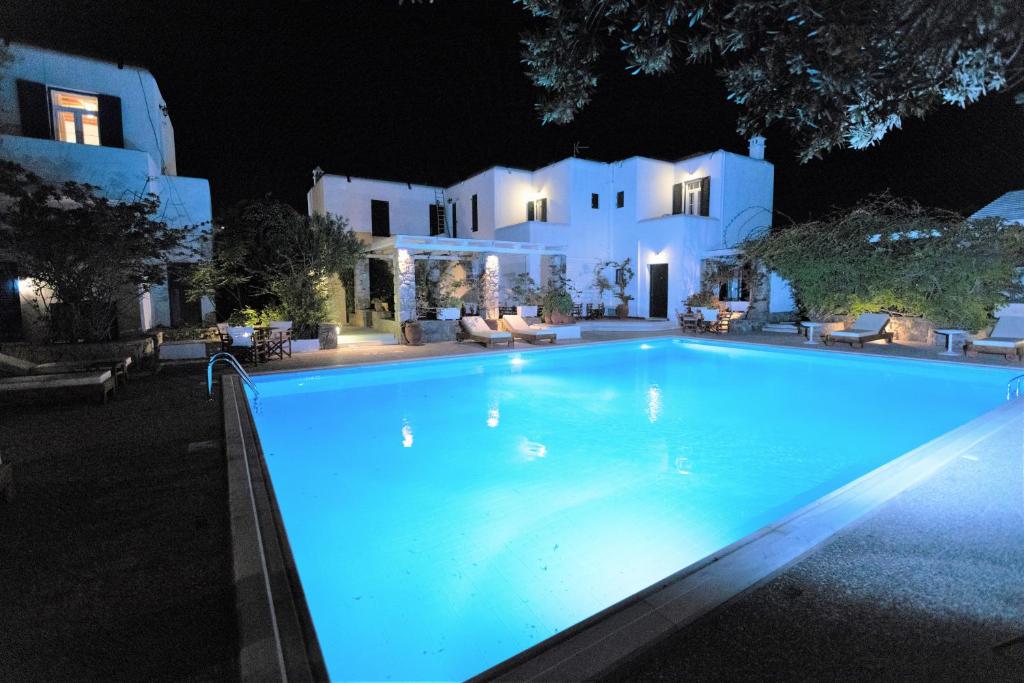 a swimming pool in front of a house at night at Petit Andromeda Mykonos I in Mikonos