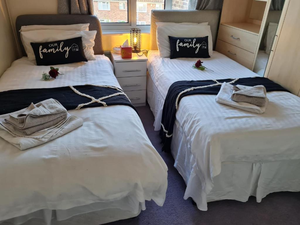 two beds with towels on them in a room at Sturry House in Sturry