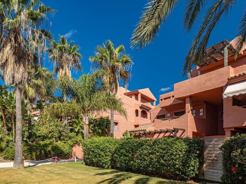 a house with palm trees in front of it at Penthouse Majestic Costa Golf Casares in Casares