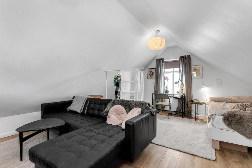 a living room with a black couch and a table at Spacious, Cozy & Family Friendly House in Reykjavík