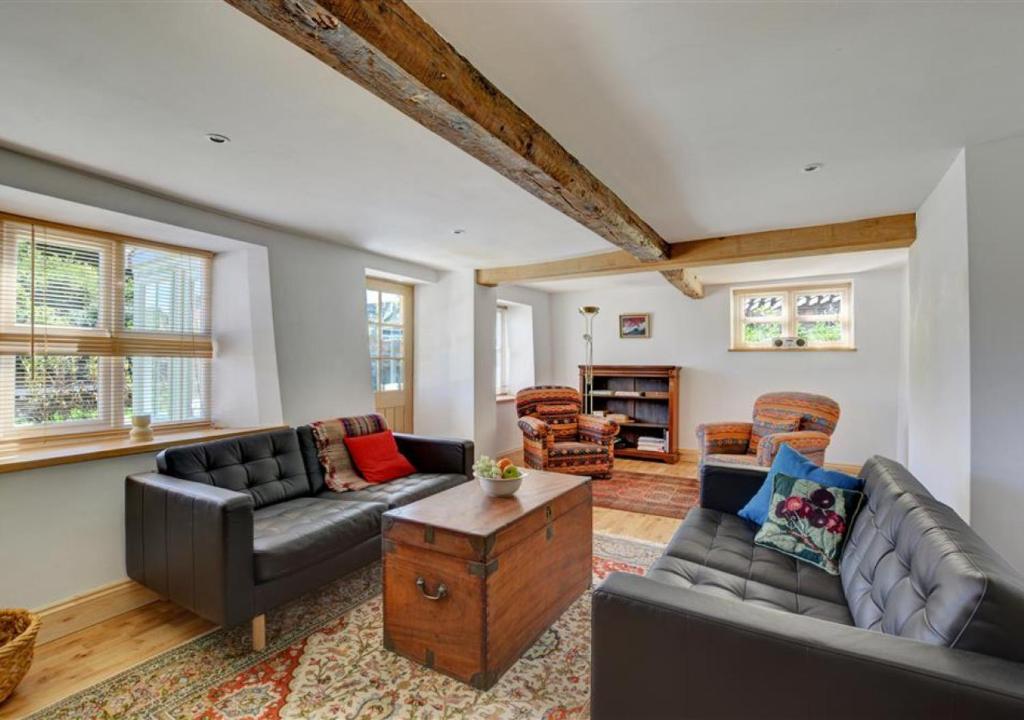 ein Wohnzimmer mit zwei Sofas und einem Tisch in der Unterkunft Rose Cottage in Stiffkey