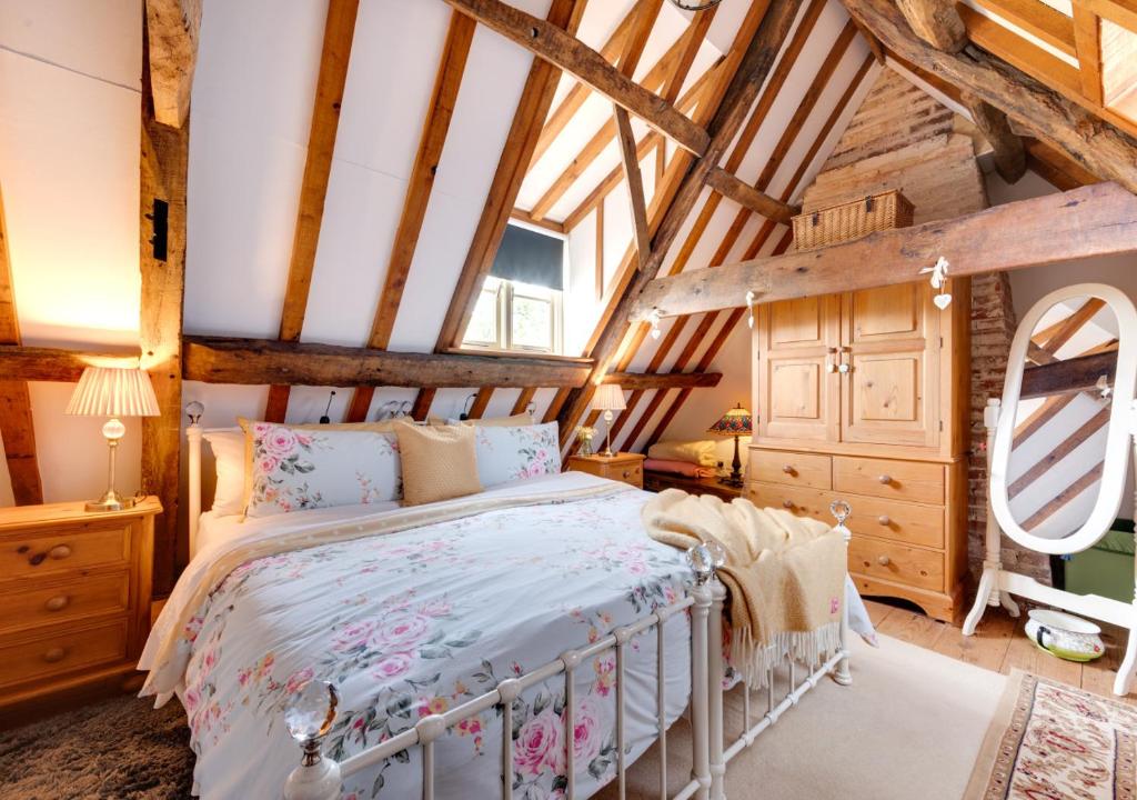 a bedroom with a bed in a room with wooden ceilings at Reclaim Cottage in Colkirk
