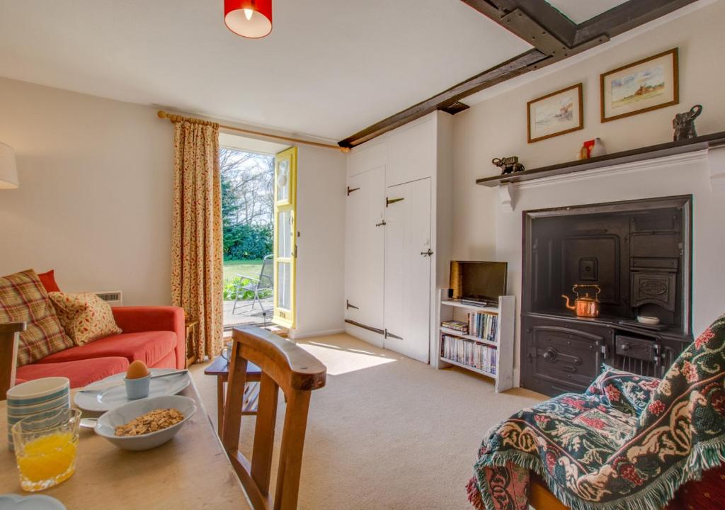 a living room with a couch and a fireplace at Reeve Cottage in Blakeney