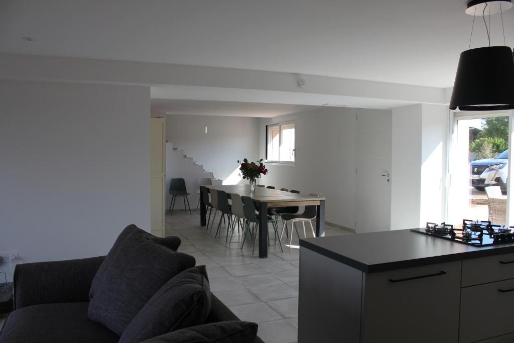 a living room and kitchen with a couch and a table at Gîte de charme pour 10 personnes in Camélas