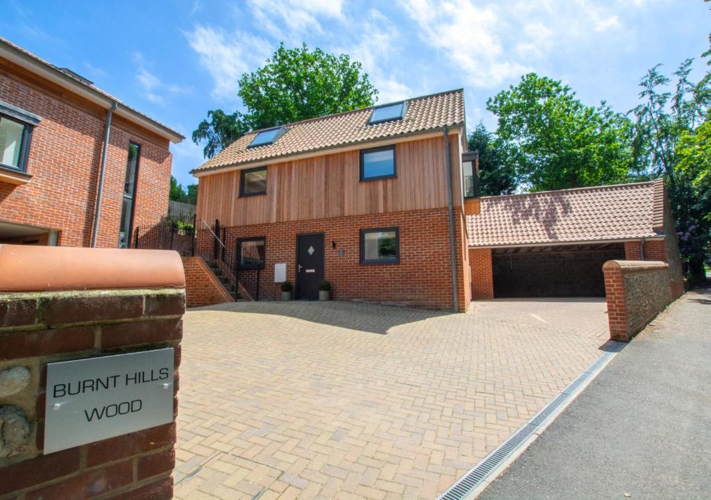 a brick building with a driveway and a garage at Station View in Cromer