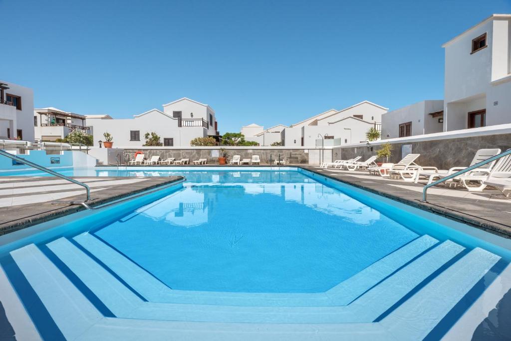 een groot zwembad met blauw water in een gebouw bij El Patrón in Playa Honda