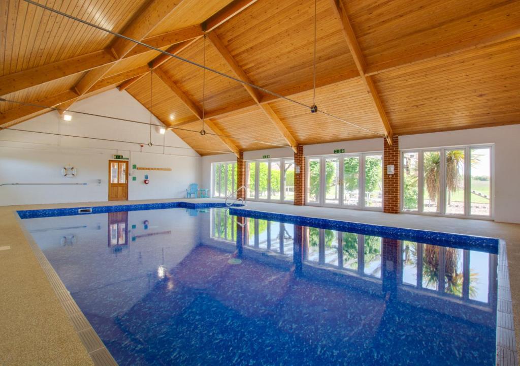 una gran piscina cubierta con techo de madera en The Antingham, en Roughton