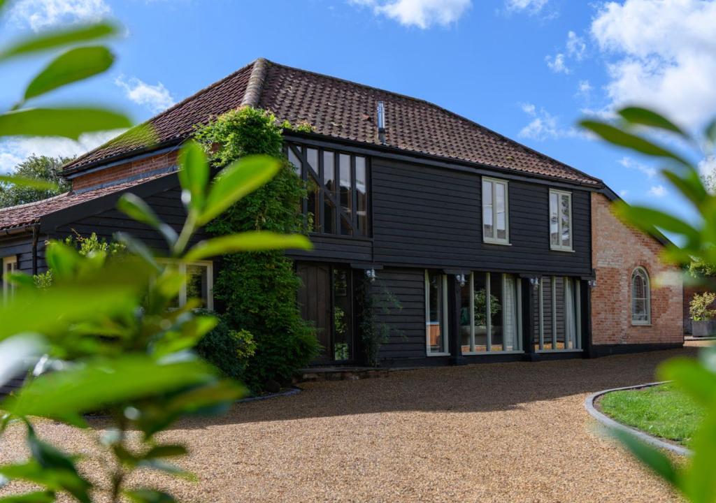 a house with black siding and ivy at The Granary 