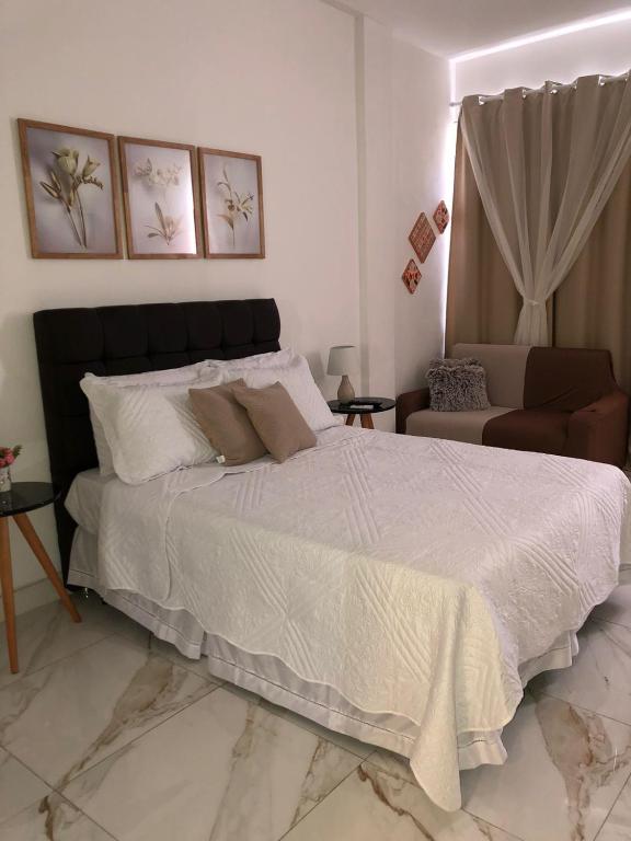 Hotel Meu Ap, a bedroom with a large bed and a couch at Meu Ap in Rio de Janeiro